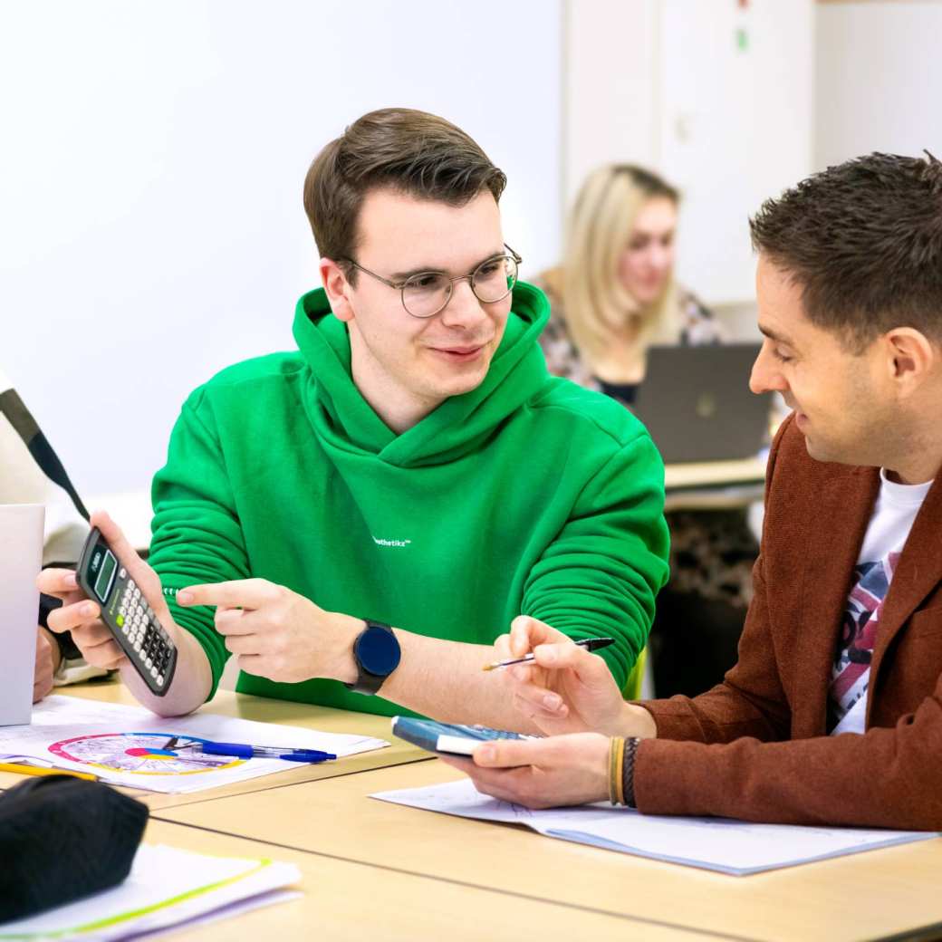 Docent economie legt student iets uit
