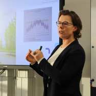 Beeld van de masterclass R-strategieën, gegeven op 20 november 2023 op locatie R31. Deelnemers zitten in de zaal. Carla Rongen, bouwbioloog, presenteert.