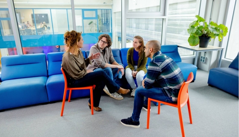 Twee studenten schaterlachen met elkaar.