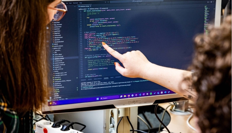 Studenten kijken samen naar coderen op de computer
