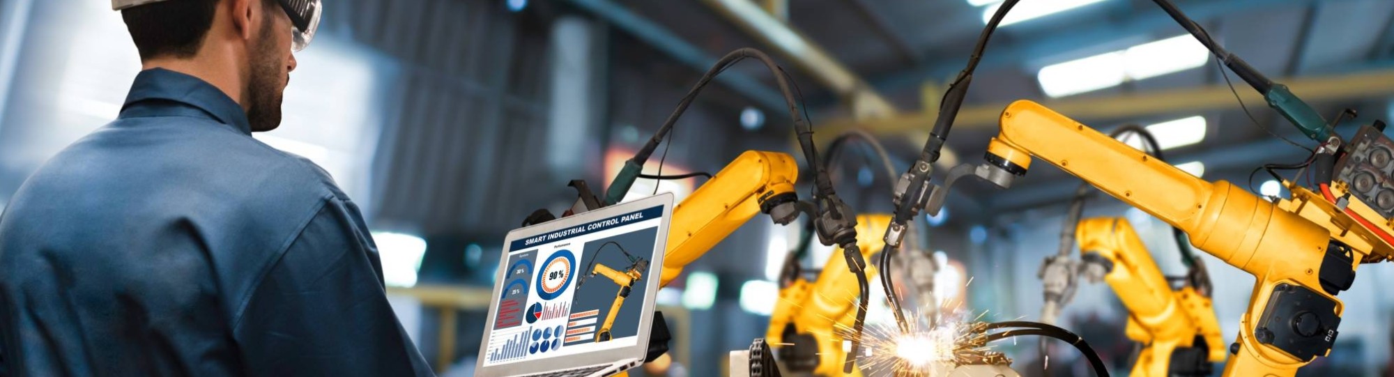 Man met tablet kijkt naar robotarmen in Digitale Fabriek