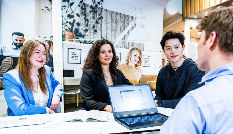 Twee studenten van de associate degree Bedrijfskunde zitten op hun laptop