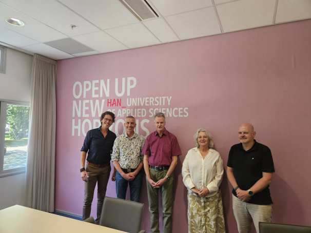 Ondertekening van de intentieverklaring van de samenwerking tussen de HAN en PPZ. Collega's van beide instellingen staan lachend op de foto en tekenen de verklaring.