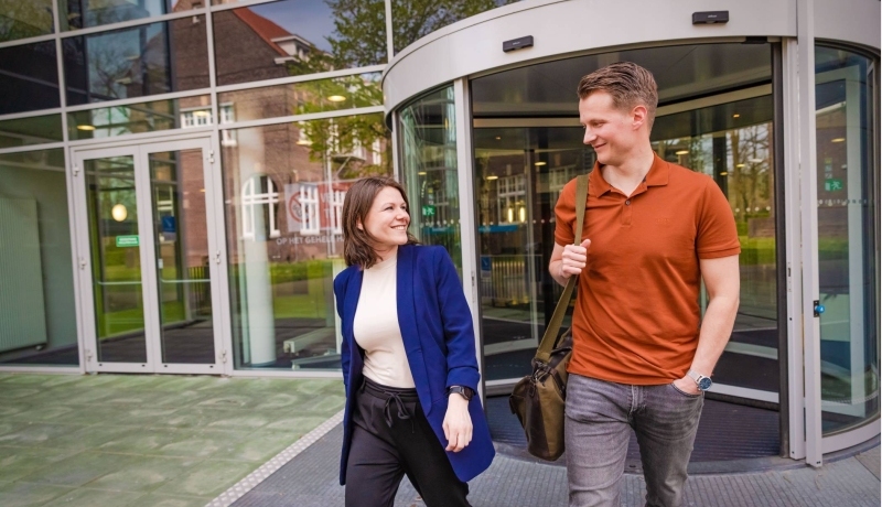 werknemer en arbeidsdeskundige lopen een gebouw uit