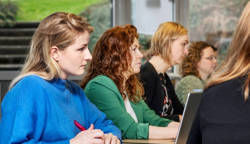 Masterstudenten kijken en luisteren aandachtig tijdens een les onderzoek van de opleiding tot verpleegkundig specialist