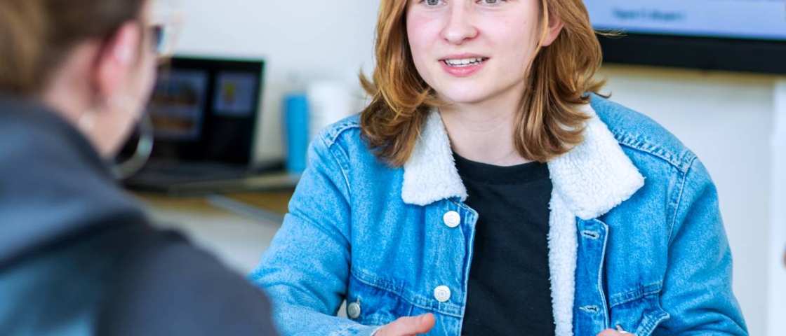 Een student kijkt een andere student aan. 
