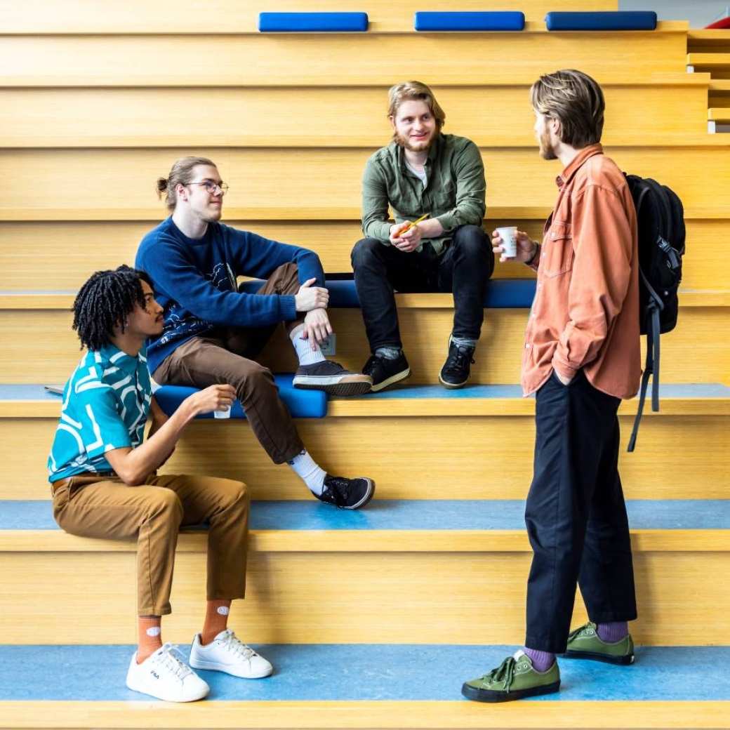 docent Vyasa groet CMD-studenten op de trap in de centrale hal