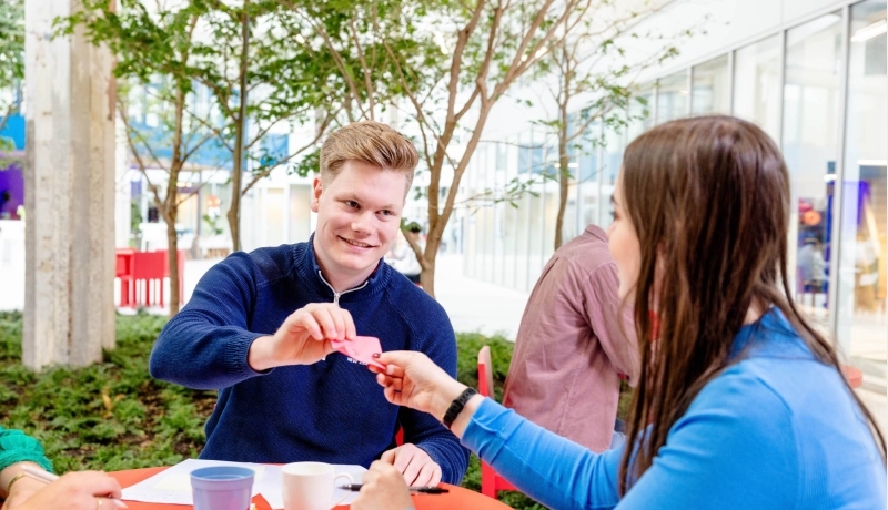 Cursist zomeropfriscursus student geeft briefje aan student