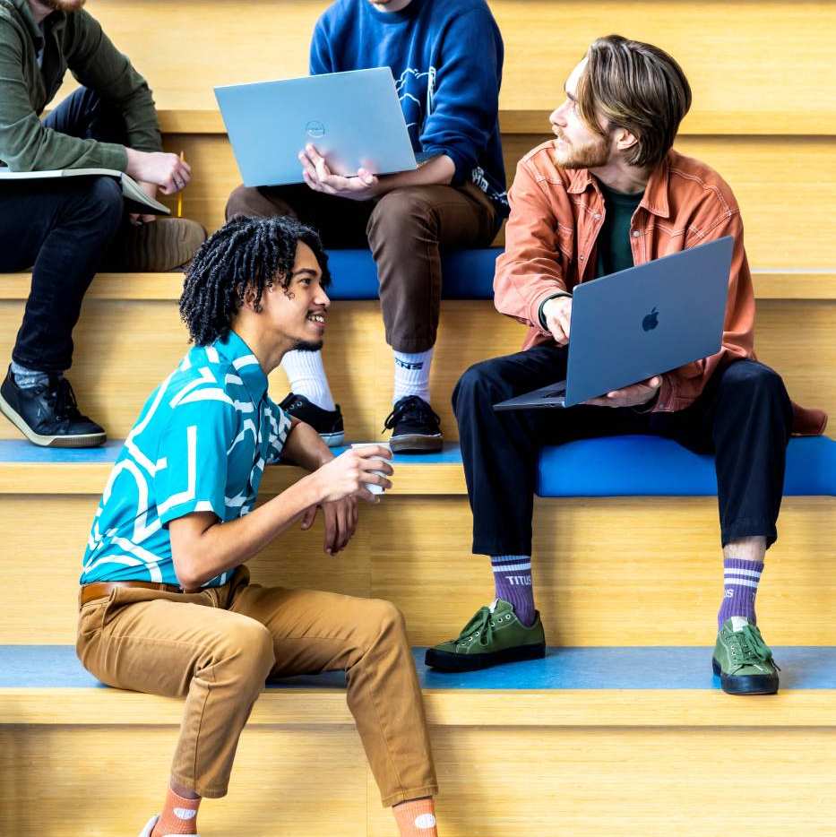 Studenten lachen en nemen contact op via hun mobiel