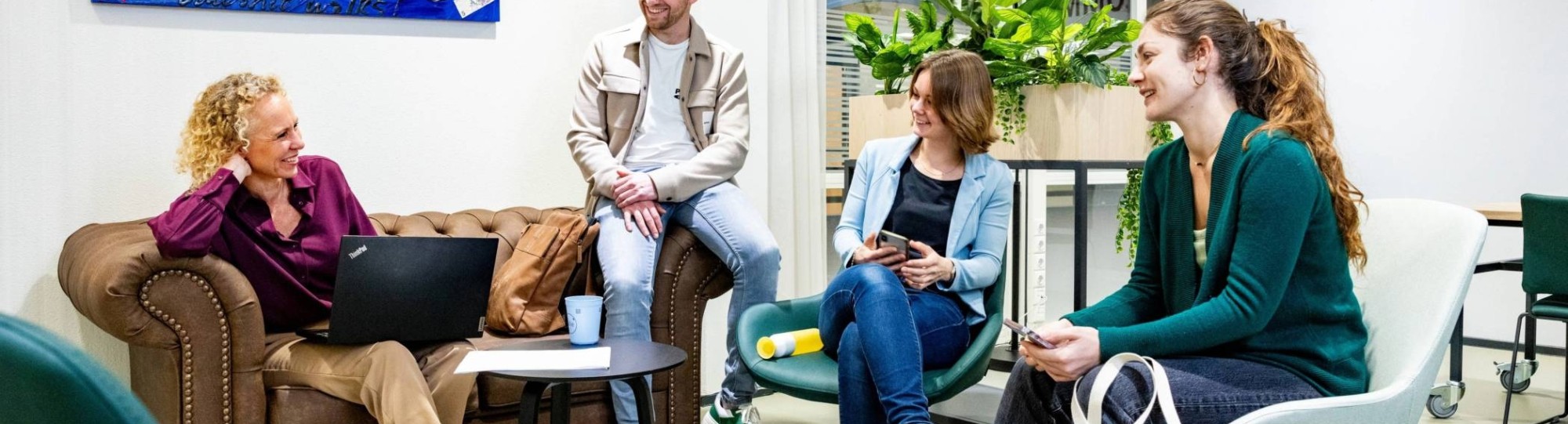 4 masterstudenten Duurzaamheidstransities in een lounge op de HAN-campus.