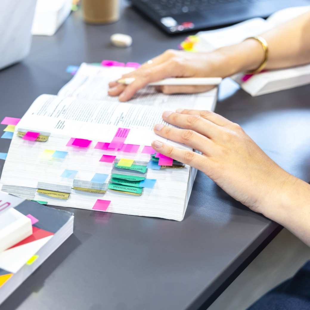 Vingers bladeren door een wettenbundel 