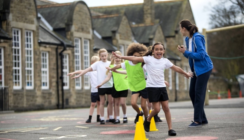 kinderen met de armen wijd aan het spelen op het schoolplein