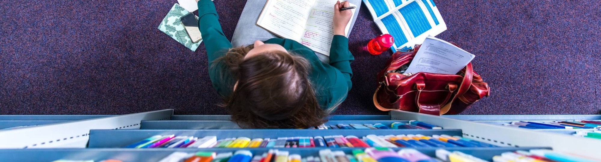 Studente studeren in studiecentrum en werken op laptop, van bovenaf