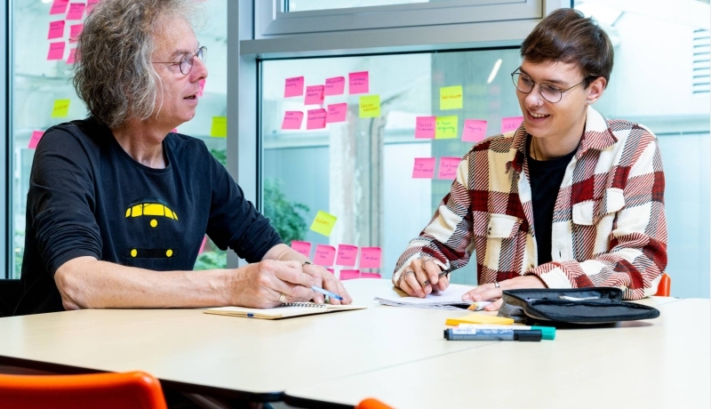 Student in gesprek met zijn docent