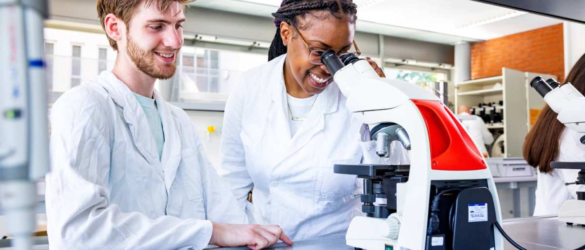 studenten aan het werk met een microscoop