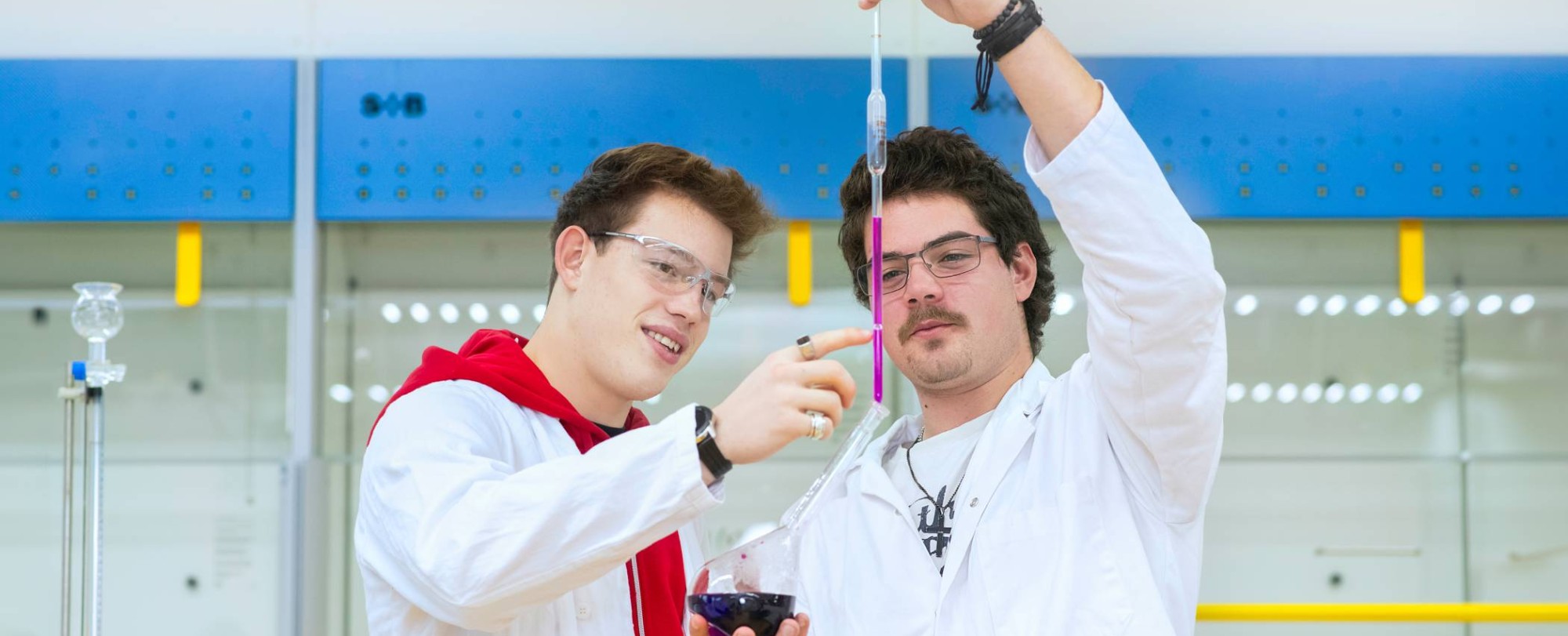 Twee studenten voegen vloeistoffen samen.