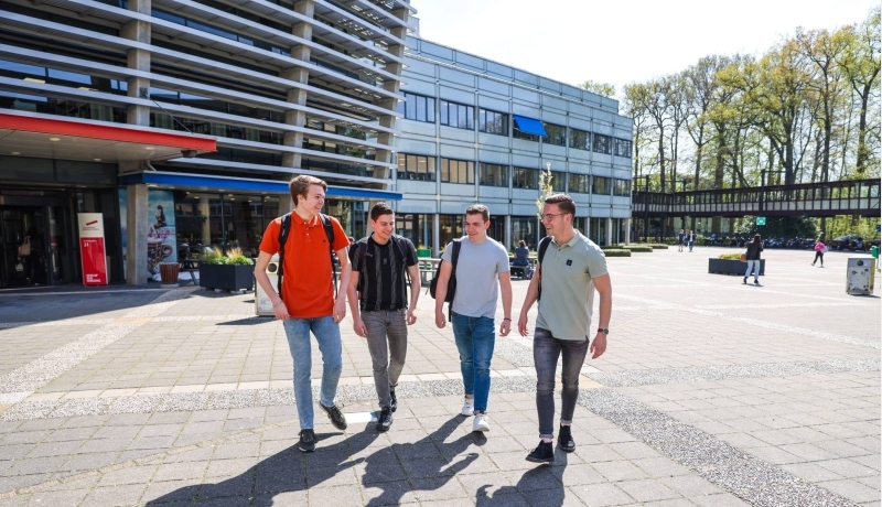 Vier studenten van logistics management lopen buiten bij de campus