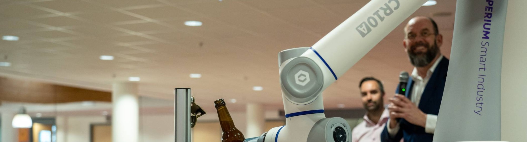 Het iXperium is geopend op 16 april. Een cobot pakt het door AI samengestelde biertje en schenkt een glas in.