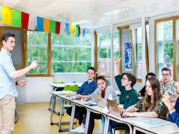 steekt vinger op in klas