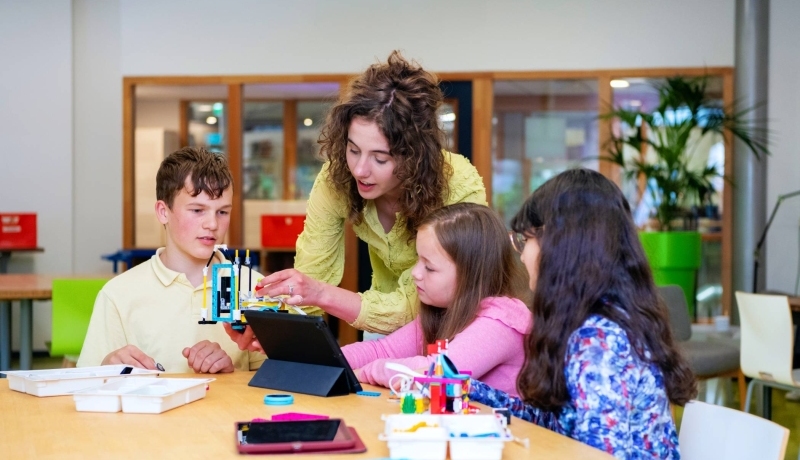 Juf begeleidt kinderen in les digitale geletterdheid