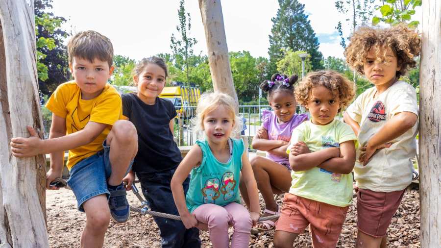 Zes kinderen poseren tijdens het buitenspelen op het klimrek. Foto van de opleiding leraar basisonderwijs 