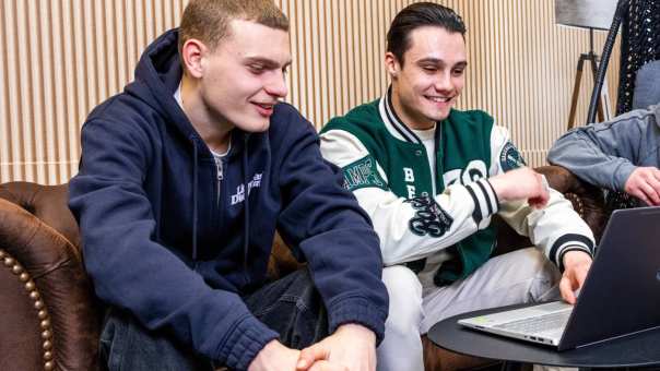 Studenten Logistics Management overleggen met een laptop erbij