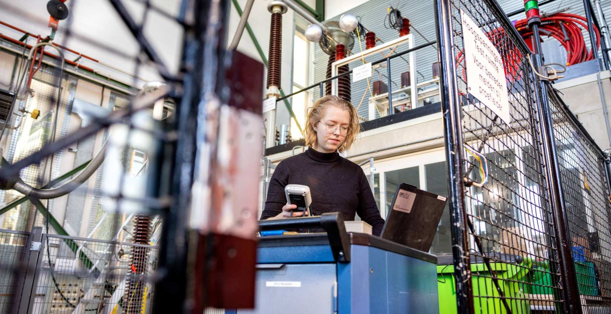 Elektrotechniekstudent Bianca in het hoogspanningslab van Qirion waar zij haar afstudeeropdracht uitvoerde. Academie Engineering en Automotive.