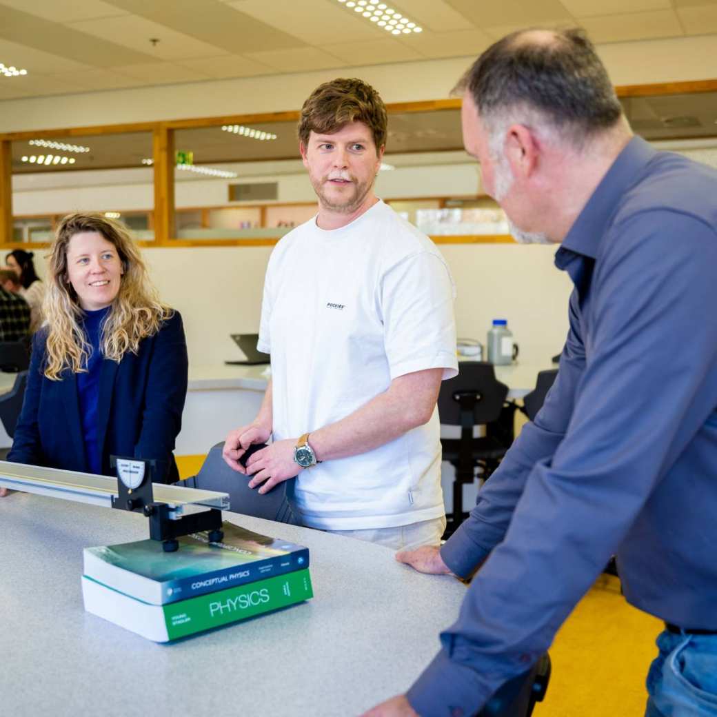 Leraar natuurkunde met stduent in gesprek