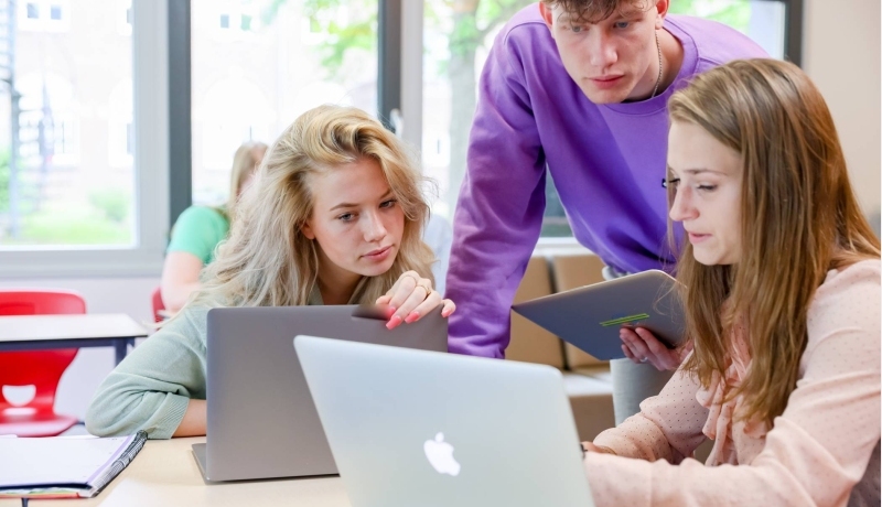 Studenten werken samen achter een laptop