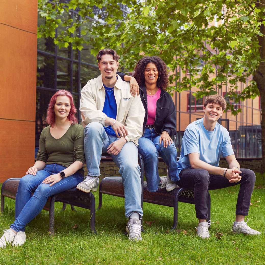 werving voltijd campagne, vier studenten in de binnentuin zitten op en aan een picnictafel