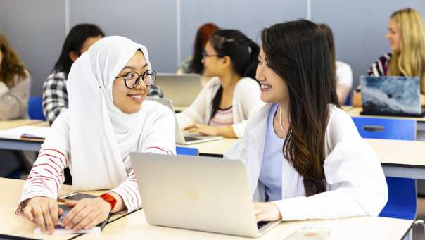 Twee studenten van de Engelstalige opleiding Communication aan de HAN overleggen over studiemateriaal