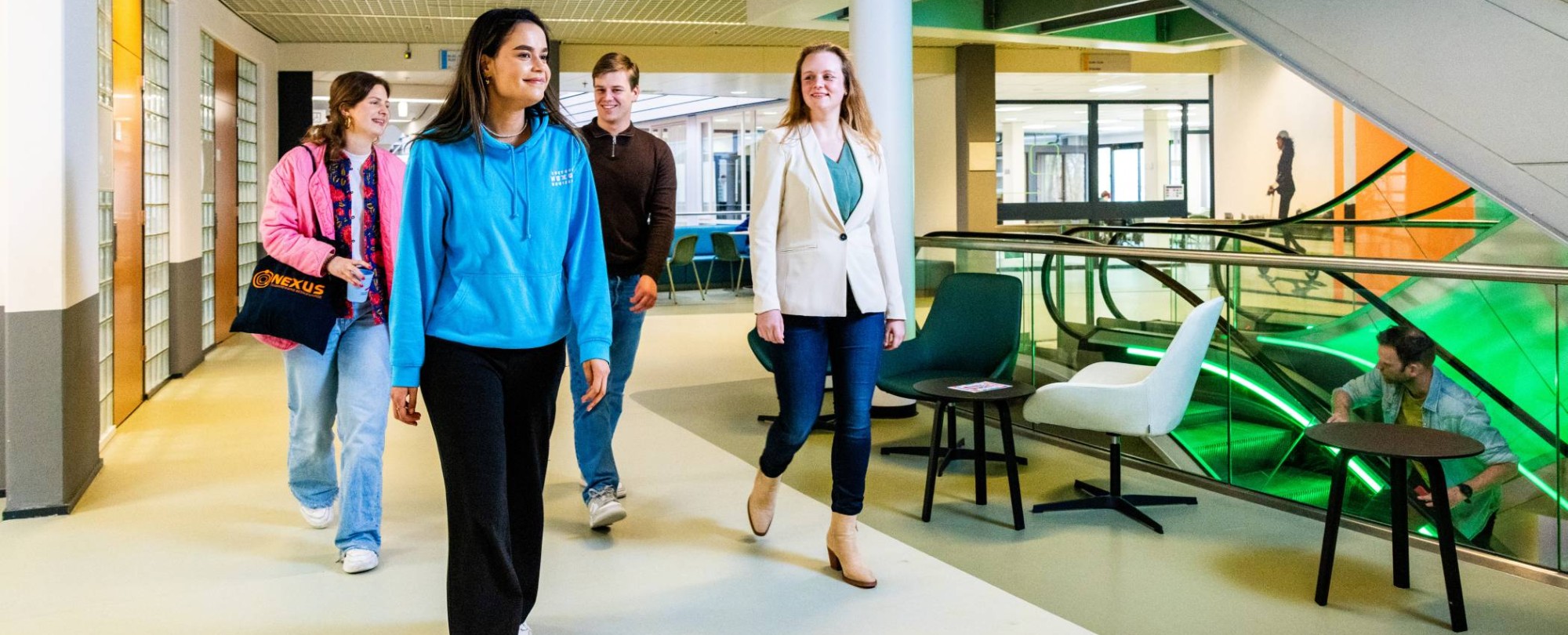 Studenten en docent van Bedrijfskunde voltijd wandelen op de gang in het gebouw