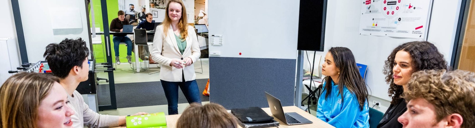 Studenten van de associate degree Bedrijfskunde zitten in de klas en luisteren naar de docent