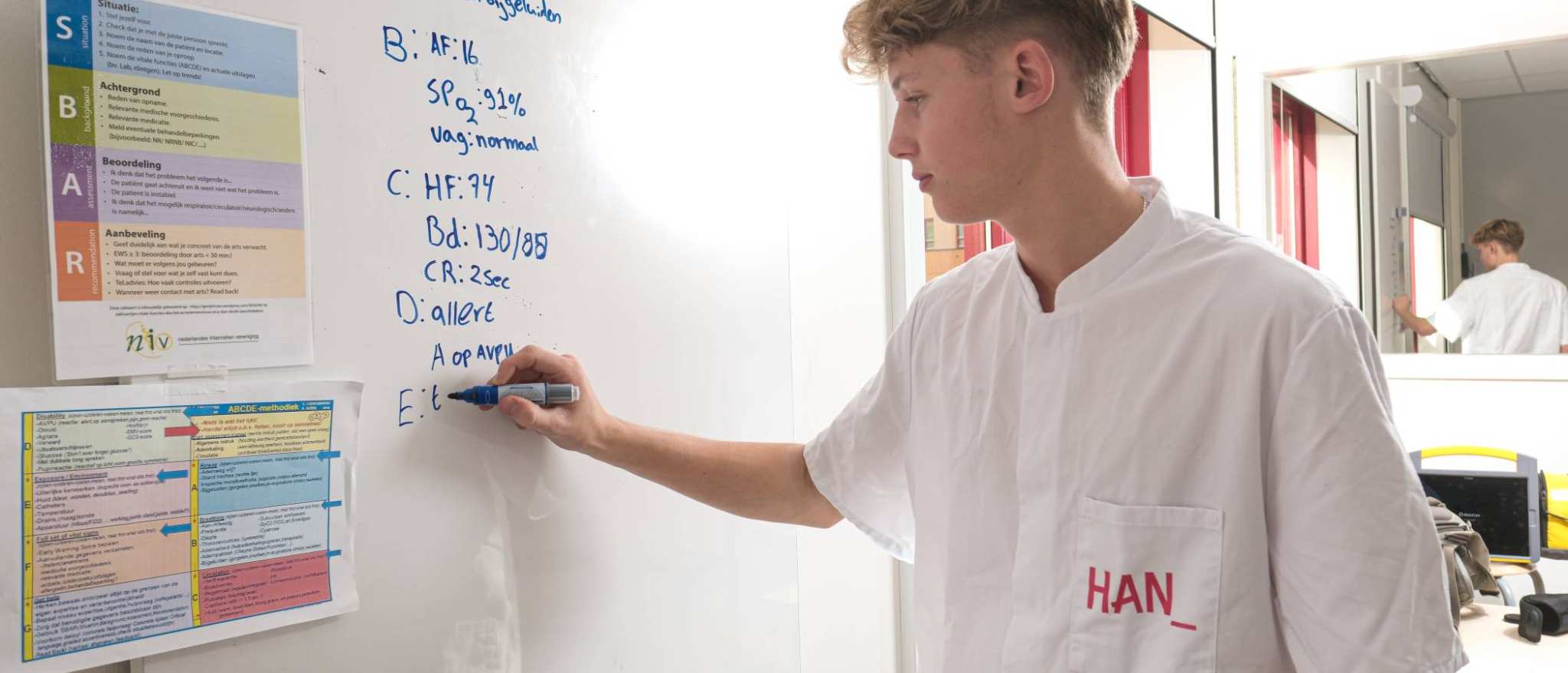 Student MHV schrijft op bord tijdens les