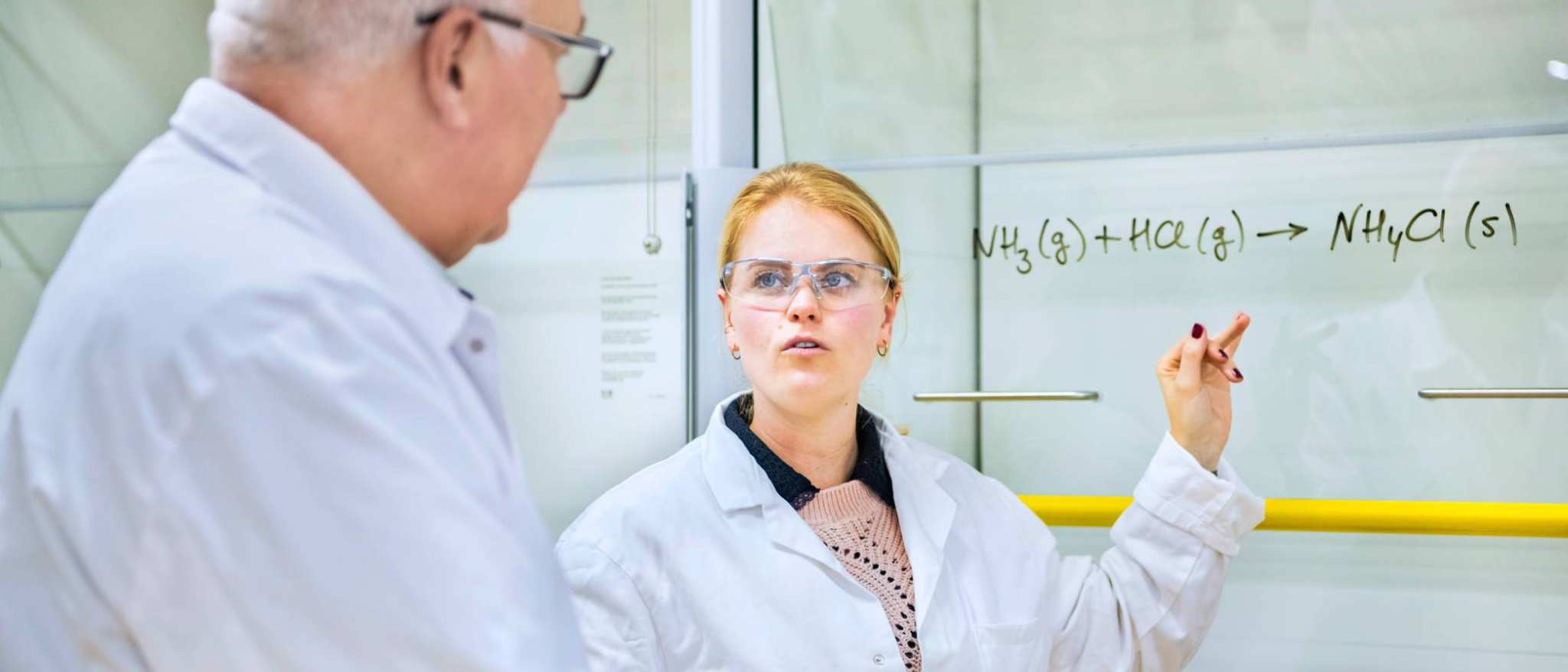 Een student legt de formule uit aan de docent.
