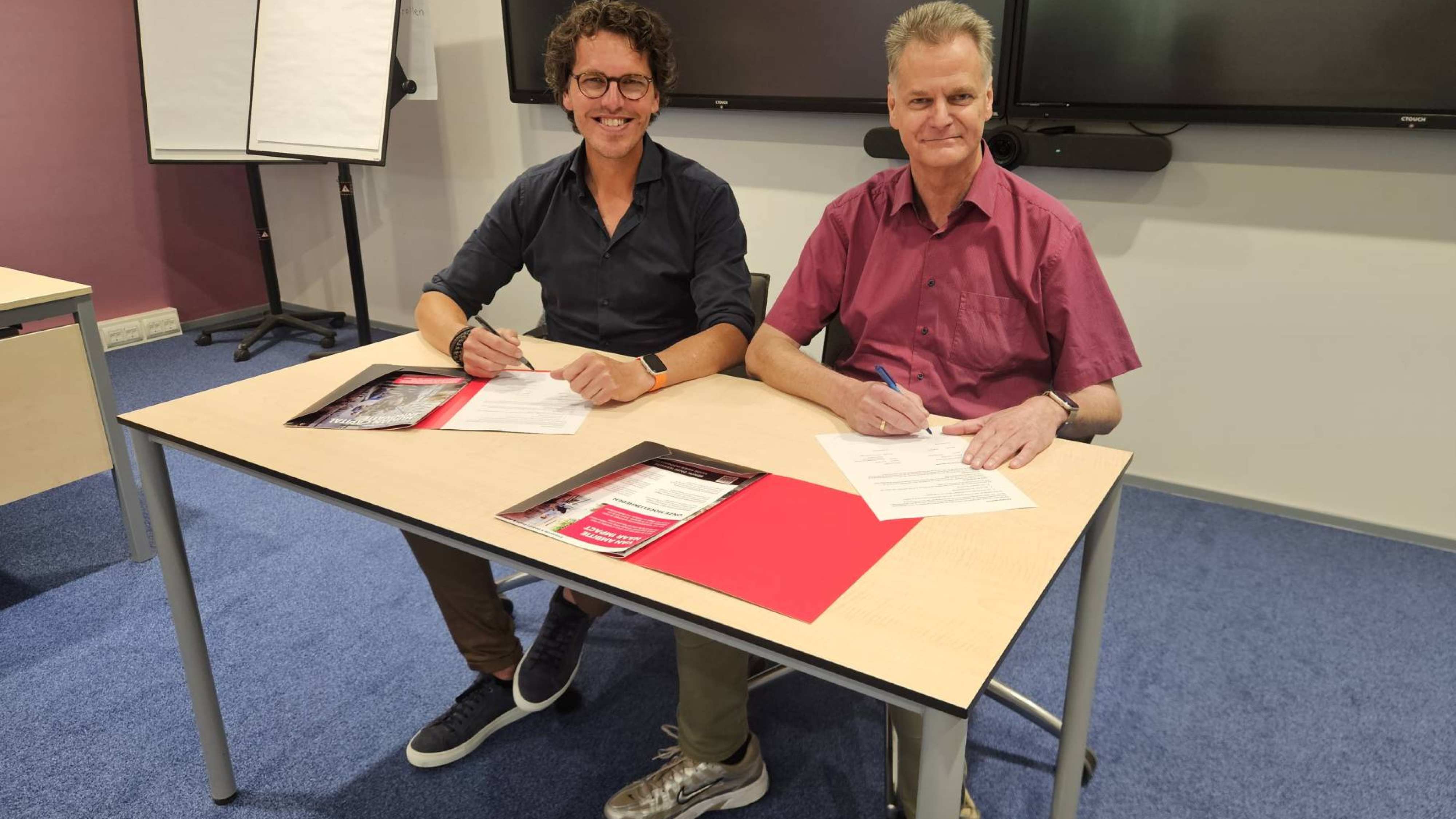 Ondertekening van de intentieverklaring van de samenwerking tussen de HAN en PPZ. Collega's van beide instellingen staan lachend op de foto en tekenen de verklaring.