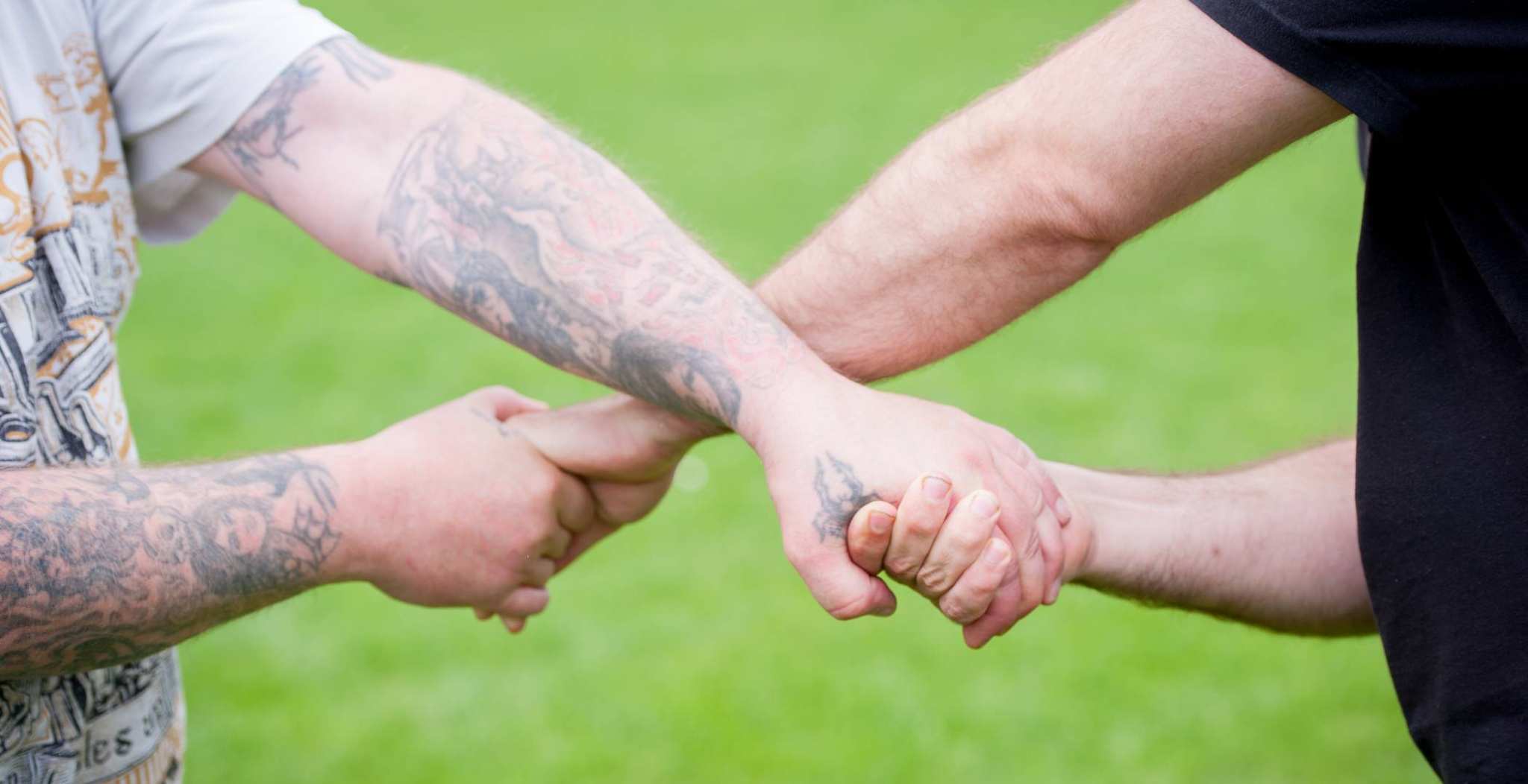 Handen van twee personen die elkaar kruislings vasthouden wat staat voor samenwerken
