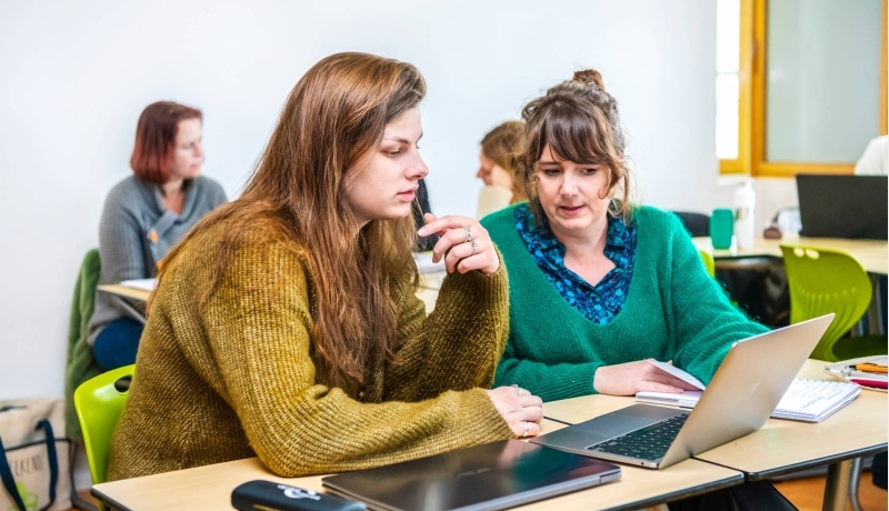 Twee studenten Leraar Engels werken samen op één laptop.