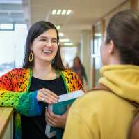 2 masterstudenten Leraar Nederlands met elkaar in gesprek op de gang,
