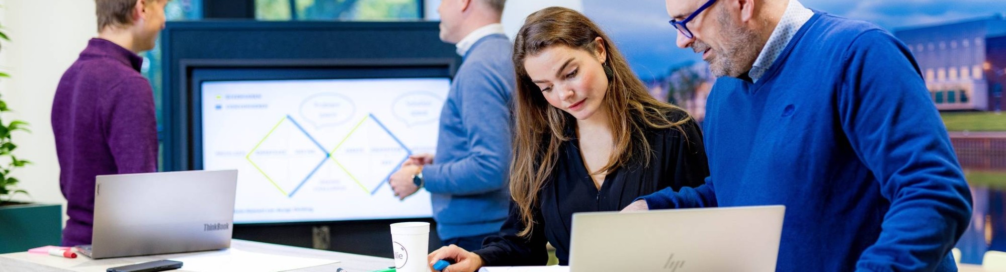 Studenten van de master Business Sales in overleg, samenwerken op laptop. 