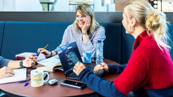 Een vrouwelijke student Social Work lacht samen met haar studiegenoten.