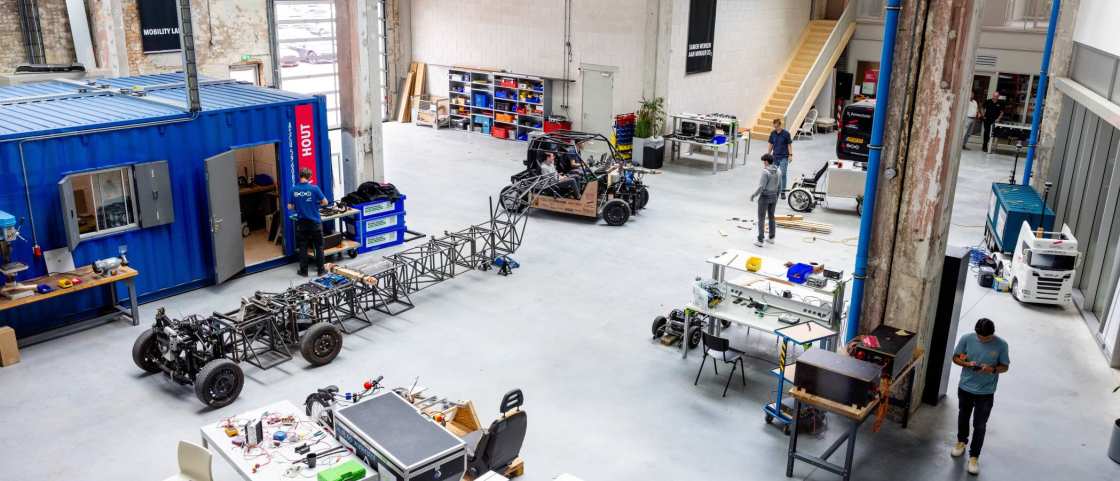 Overzichtsfoto van de grote hal, de grote ruimte, Mobility lab, van HAN Connectr op het IPKW.
In de hal zie je de waterstof bakfiets en de H2-demonstrator, ook zie je het voertuig MORE. Automotive Research