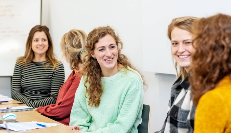 Lachende masterstudenten overleggen samen tijdens een klassikale les onderzoek op de HAN in Nijmegen