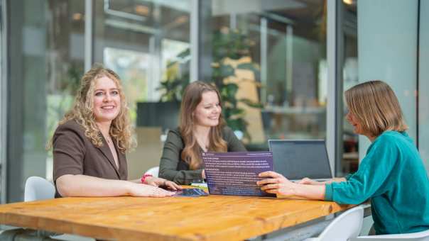 Studenten van de master Duurzaamheidstransities aan tafel samenwerken.