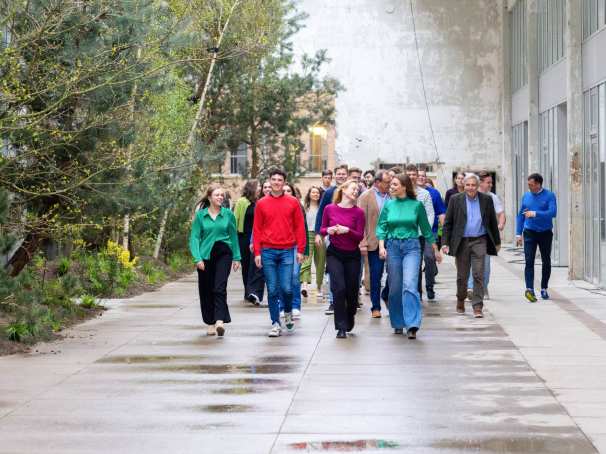 Groep studenten en docenten wandelt door IPKW met groen op de achtergrond. Fotografie Master Circulaire Economie voltijd.