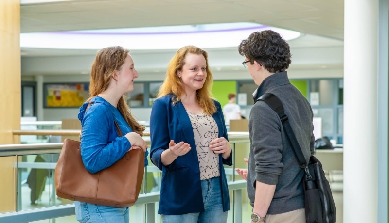 Twee studenten van hbo Bedrijfskunde in gesprek met een docent