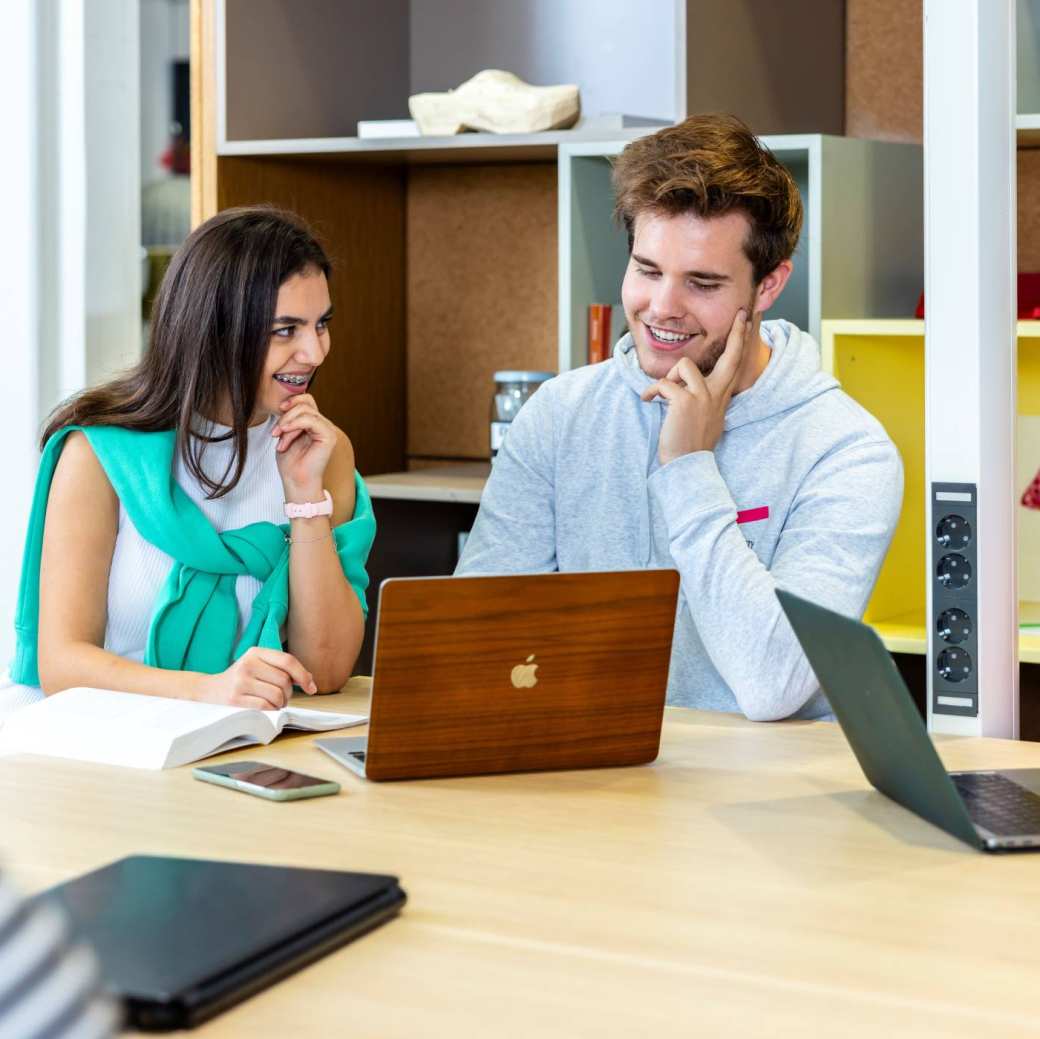 Studenten achter laptop in lokaal