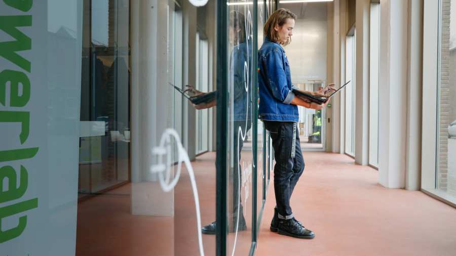 Leunende Joris met een laptop in z'n handen. SEECE, hybride leeromgeving, IPKW, MIC, Powerlab, Engineering, Elektrotechniek, Werktuigbouwkunde, Industrieel Product Ontwerpen