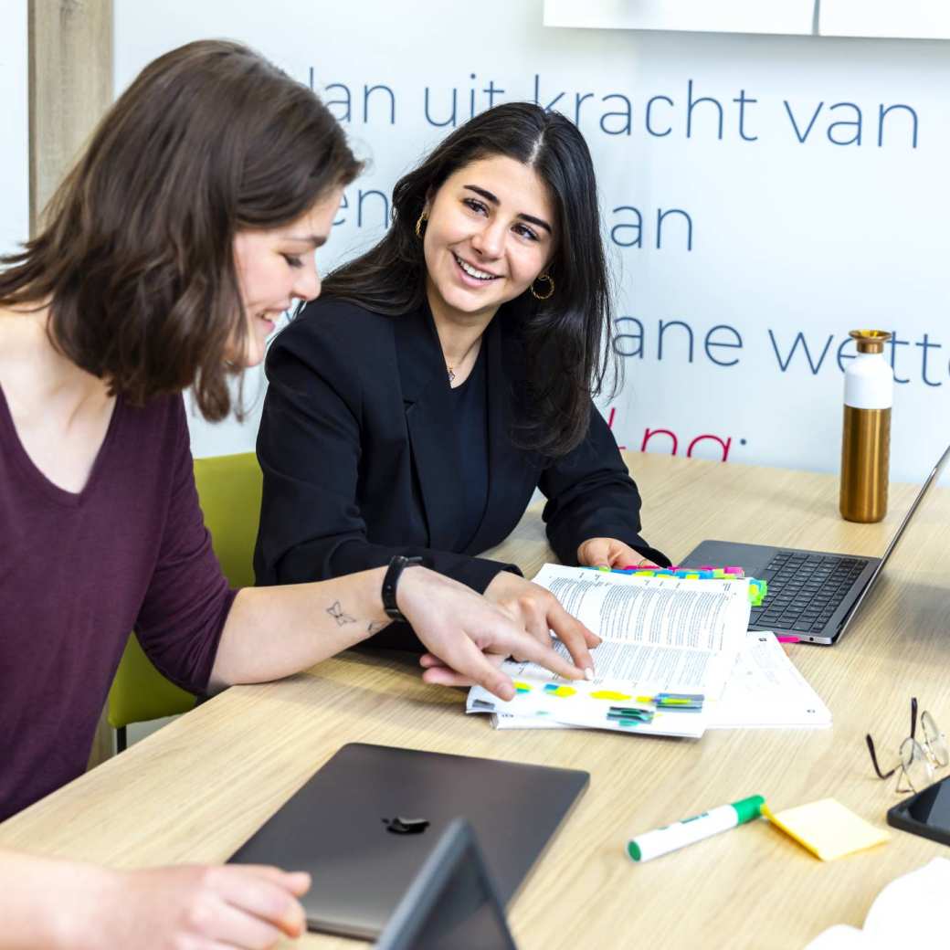 Studenten wijzen iets aan in de wettenbundel