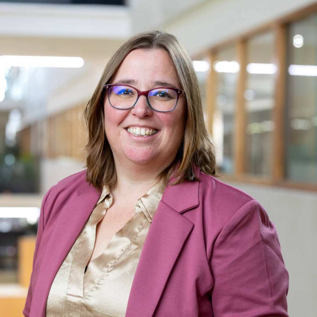 Brildragend. Bruin gemeleerde blouse met daarover heen een oudroze jasje